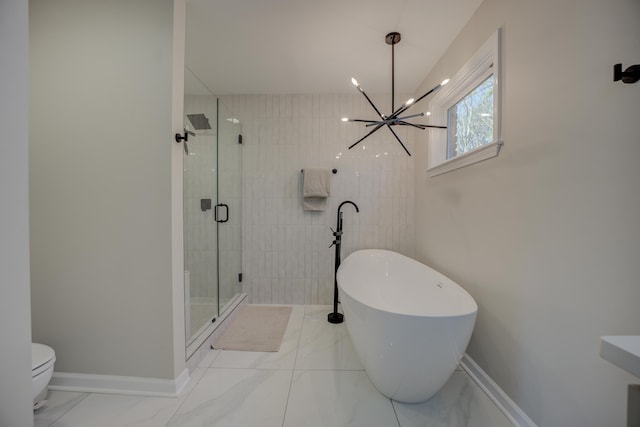 bathroom featuring baseboards, a soaking tub, marble finish floor, and a stall shower