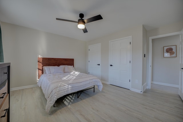 bedroom with a ceiling fan, light wood-type flooring, and baseboards