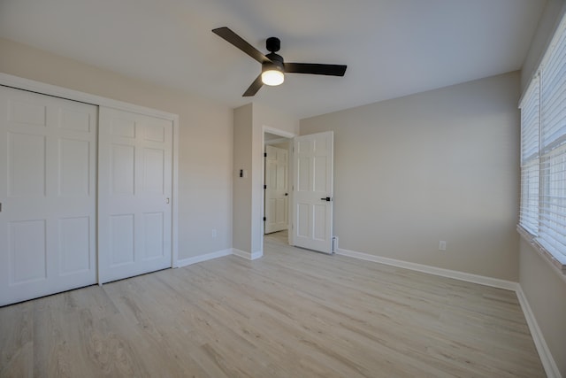 unfurnished bedroom featuring light wood-type flooring, baseboards, a closet, and a ceiling fan