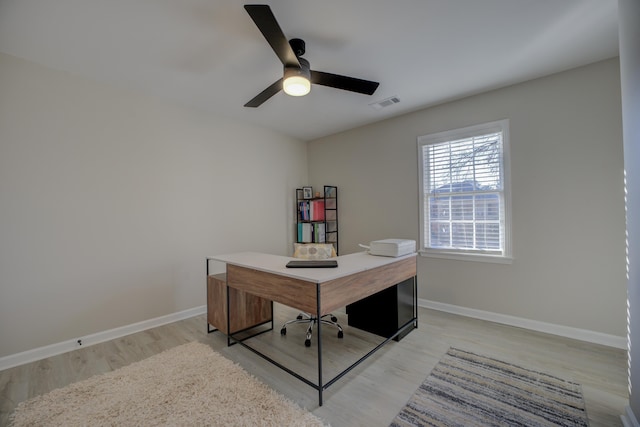 office area with a ceiling fan, light wood-style flooring, baseboards, and visible vents