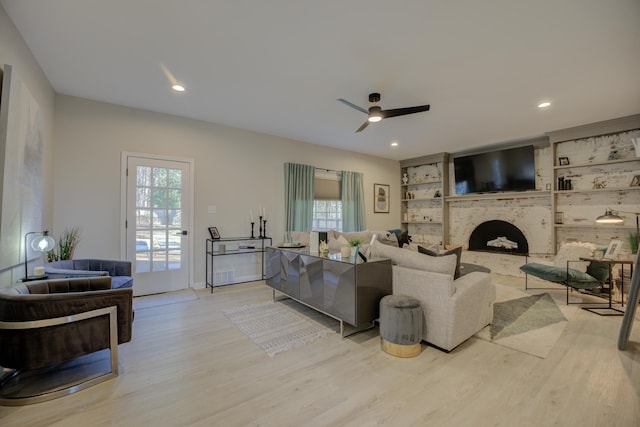 living room featuring recessed lighting, ceiling fan, a brick fireplace, and light wood-style floors