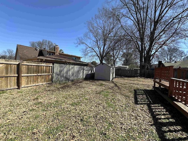 view of yard with an outbuilding, a shed, and a fenced backyard