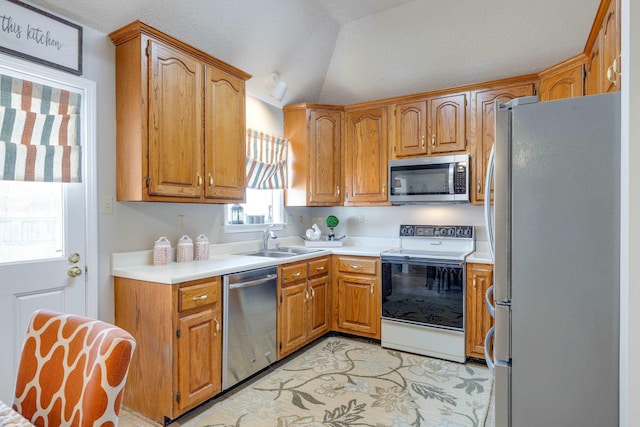 kitchen featuring a sink, stainless steel appliances, and brown cabinetry