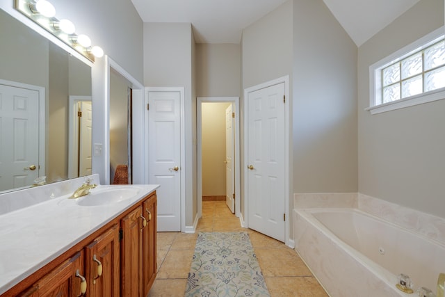 full bath with tile patterned floors, a tub with jets, and vanity