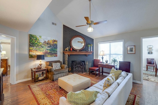 living room featuring visible vents, baseboards, hardwood / wood-style floors, and a fireplace