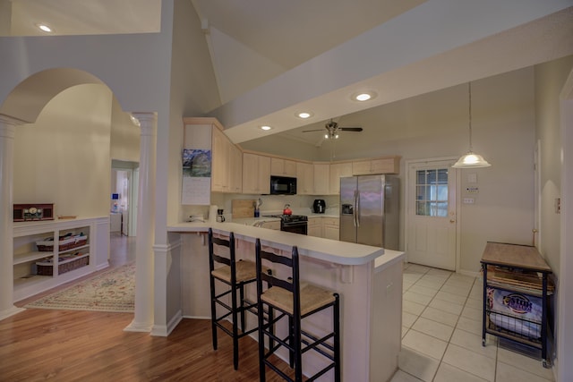 kitchen with a ceiling fan, a peninsula, decorative columns, black appliances, and light countertops