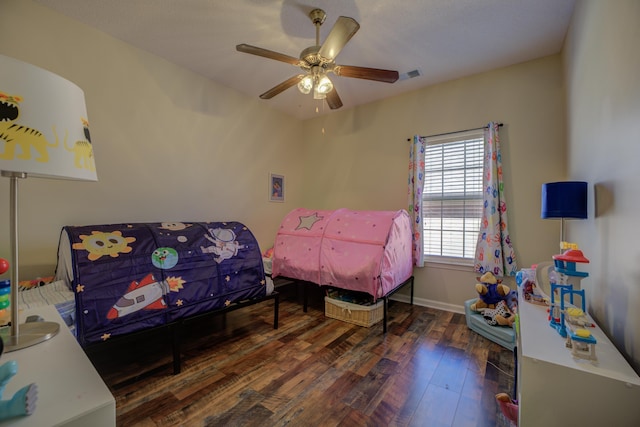 bedroom featuring hardwood / wood-style floors, a ceiling fan, visible vents, and baseboards