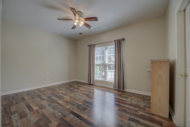 empty room with visible vents, a textured ceiling, wood finished floors, baseboards, and ceiling fan