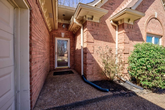 view of exterior entry featuring brick siding