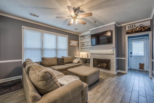 living room with ornamental molding, wood finished floors, visible vents, and a textured ceiling