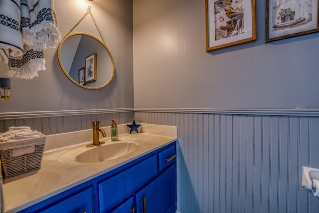 bathroom with vanity and a wainscoted wall