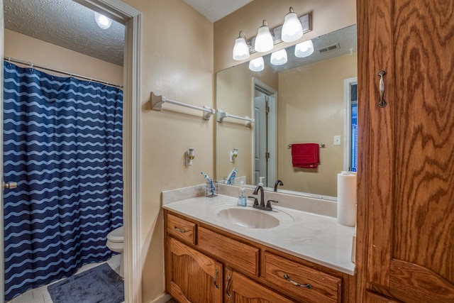 full bath featuring visible vents, toilet, vanity, a shower with curtain, and a textured ceiling