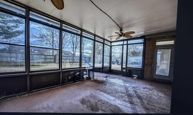 unfurnished sunroom featuring ceiling fan