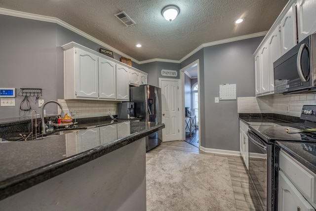 kitchen featuring visible vents, stainless steel refrigerator with ice dispenser, black electric range, a sink, and white cabinetry