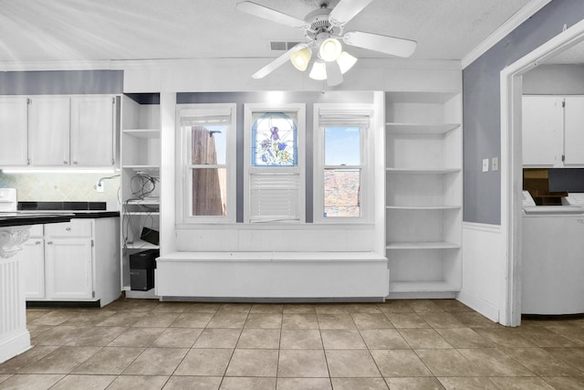 kitchen with visible vents, crown molding, washer / dryer, white cabinets, and open shelves