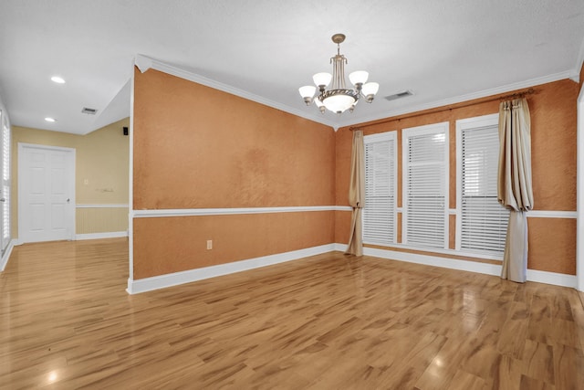 unfurnished room featuring ornamental molding, visible vents, light wood finished floors, and a chandelier