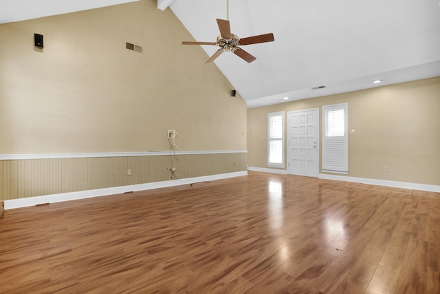 unfurnished living room featuring ceiling fan, visible vents, high vaulted ceiling, and wood finished floors