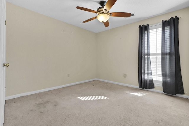 carpeted empty room with visible vents, baseboards, and ceiling fan