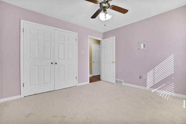 unfurnished bedroom with a closet, carpet flooring, visible vents, and baseboards