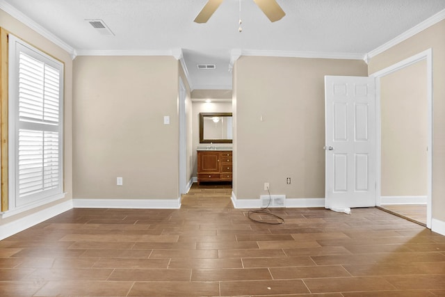 unfurnished room featuring visible vents, ornamental molding, and wood finished floors