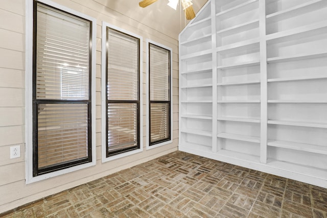 unfurnished sunroom featuring a ceiling fan