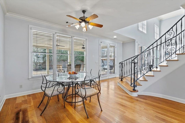 dining area featuring crown molding, baseboards, and wood finished floors