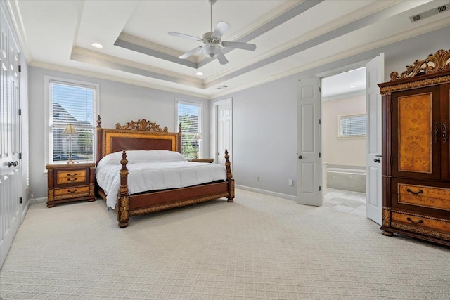 bedroom featuring a tray ceiling, multiple windows, crown molding, and visible vents