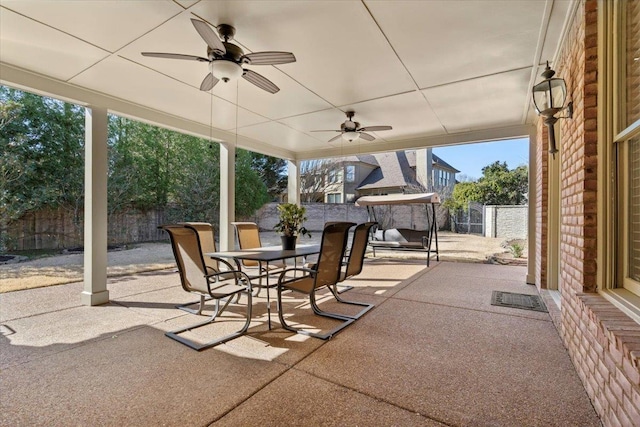 view of patio featuring outdoor dining area, a ceiling fan, and fence