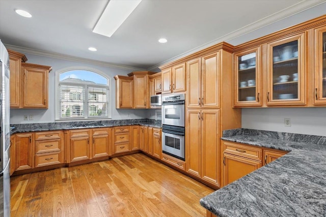 kitchen with stainless steel appliances, glass insert cabinets, ornamental molding, and light wood finished floors