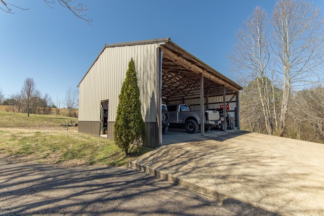 view of pole building with a detached carport and driveway