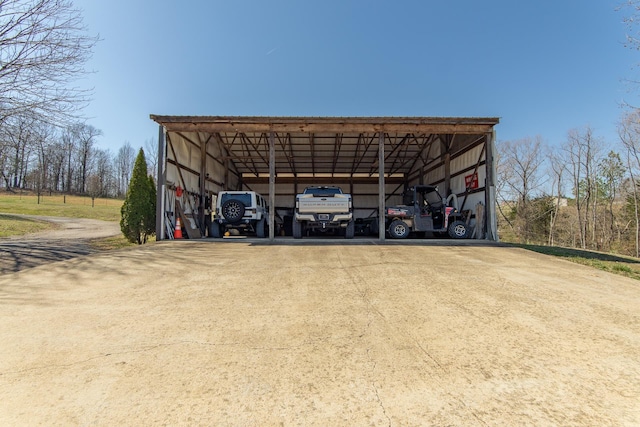 exterior space with a detached carport, driveway, and a pole building