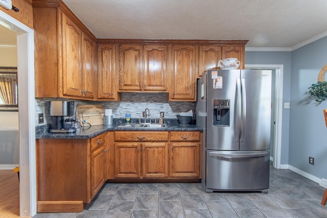 kitchen with a sink, brown cabinetry, and stainless steel refrigerator with ice dispenser