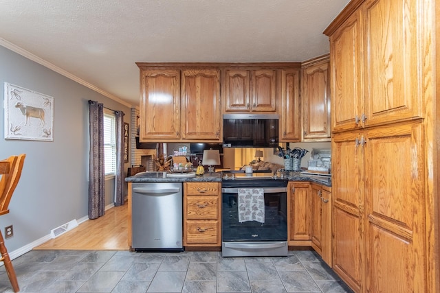 kitchen with dark countertops, brown cabinetry, visible vents, and stainless steel appliances