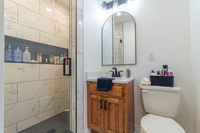 full bathroom featuring a shower stall, toilet, and vanity