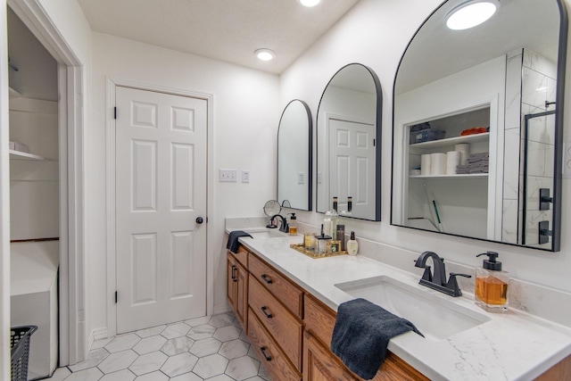 full bathroom featuring a sink, an enclosed shower, double vanity, and tile patterned flooring