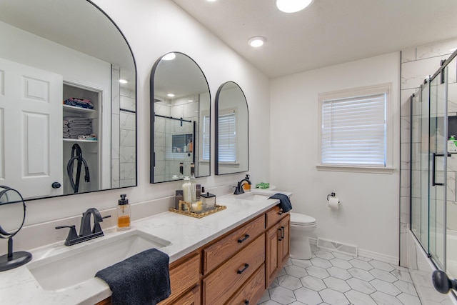 bathroom featuring double vanity, visible vents, toilet, and a sink