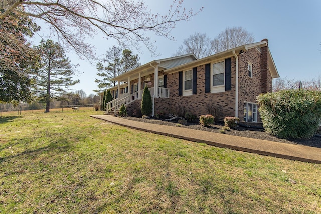 single story home featuring a front yard, a porch, fence, and brick siding