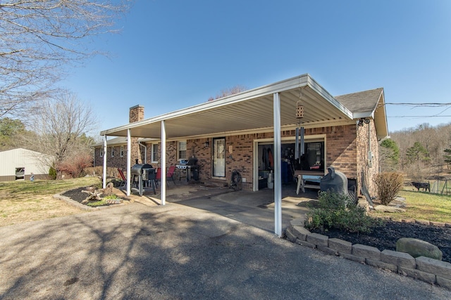 view of parking / parking lot with an attached carport, aphalt driveway, and a garage