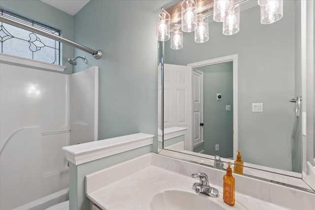 bathroom featuring walk in shower and vanity