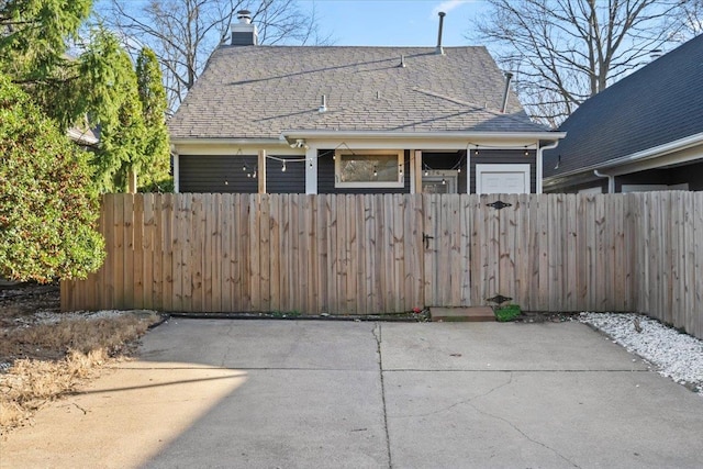 exterior space featuring a shingled roof and fence