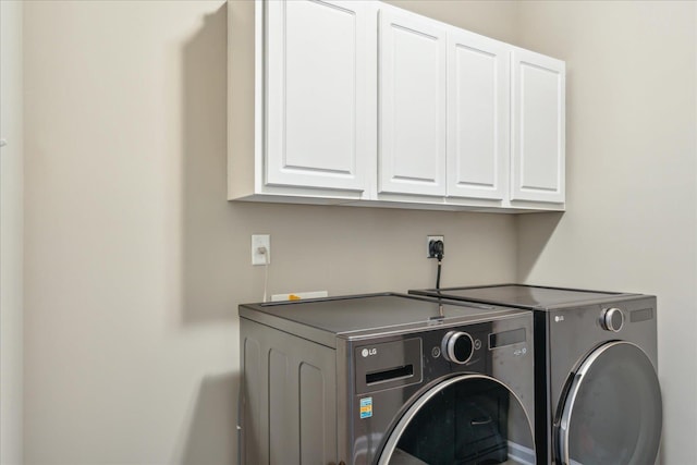 washroom with washer and dryer and cabinet space