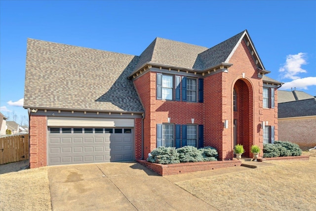 view of front of home with driveway, fence, roof with shingles, a garage, and brick siding