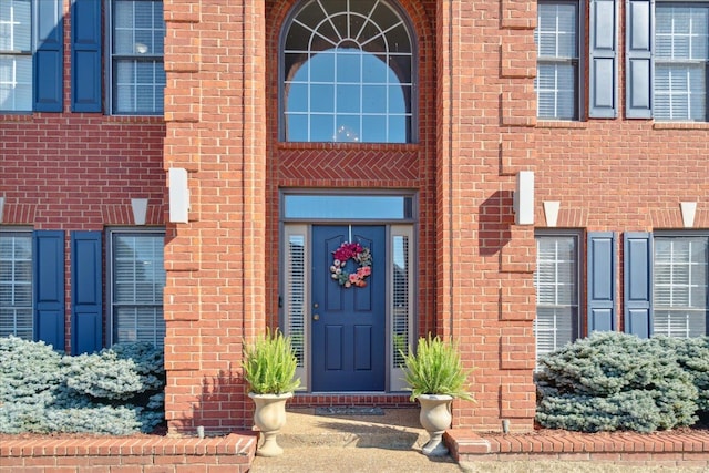 view of exterior entry with brick siding