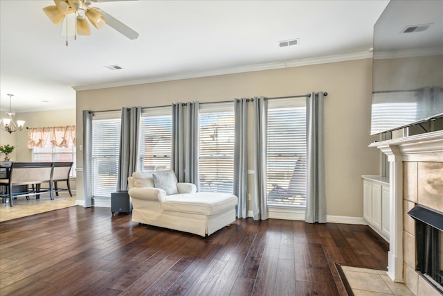 living room featuring a tiled fireplace, wood finished floors, and visible vents