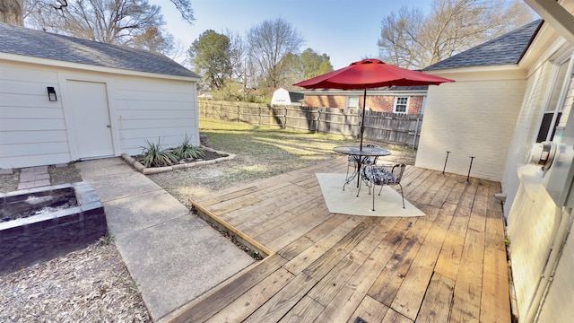 wooden terrace featuring a lawn and fence