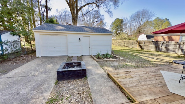 detached garage with driveway and fence