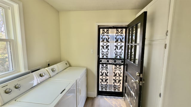 laundry room featuring laundry area, wood finished floors, and washer and clothes dryer