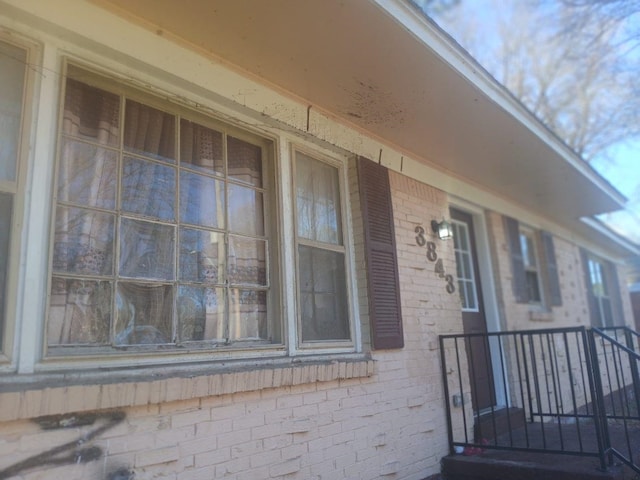 view of exterior entry featuring brick siding