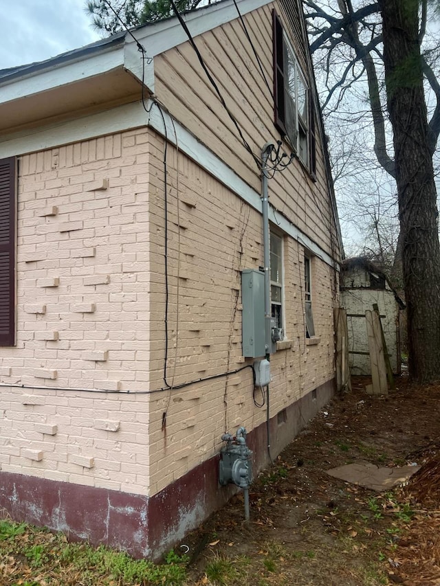 view of side of property with crawl space and brick siding