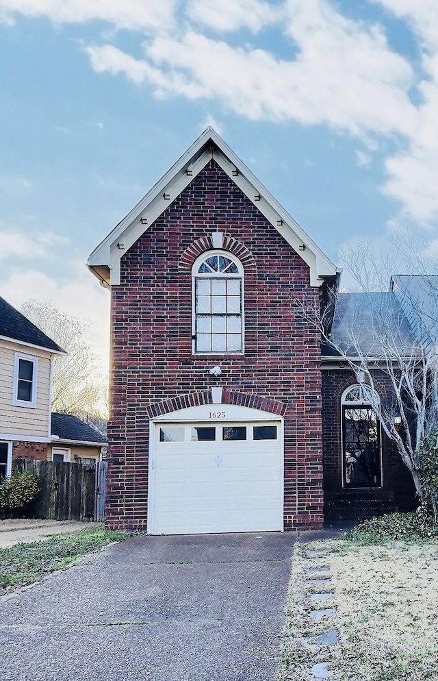 view of front of house featuring a garage, brick siding, driveway, and fence